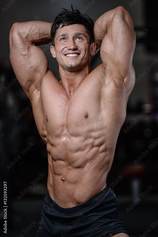 Handsome bodybuilder training in the gym sexy man lift dumbbells Handsome bodybuilder training in the gym sexy man lift dumbbells