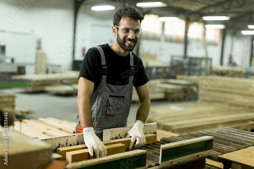 Handsome young man working in the lumber factory