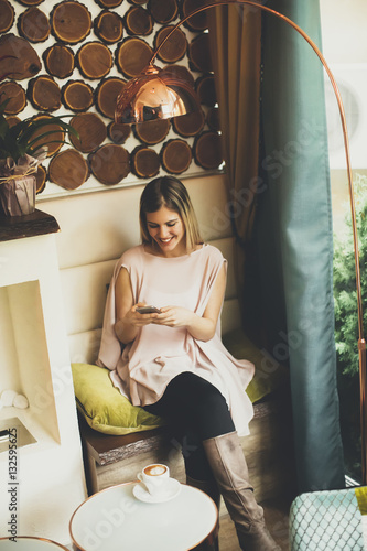 Woman sitting in cafe and u...