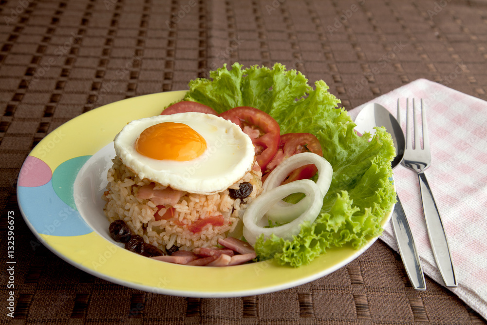 Fry rice with ham , tomato , onion , raisin and egg on top. Fry rice with ham , tomato , onion , raisin and egg on top.
