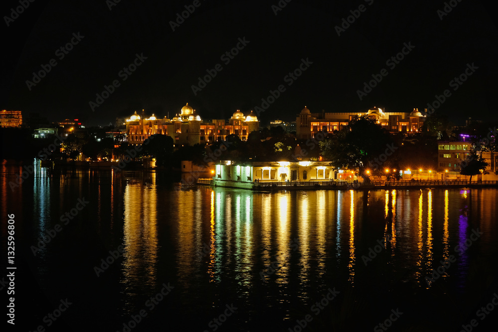 Night time reflections of the city of Udaipur on lake Pichola in Rajasthan