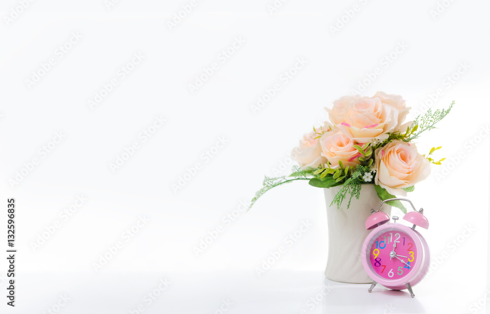 Pink alarm clock and bouquet on the white background with copy s