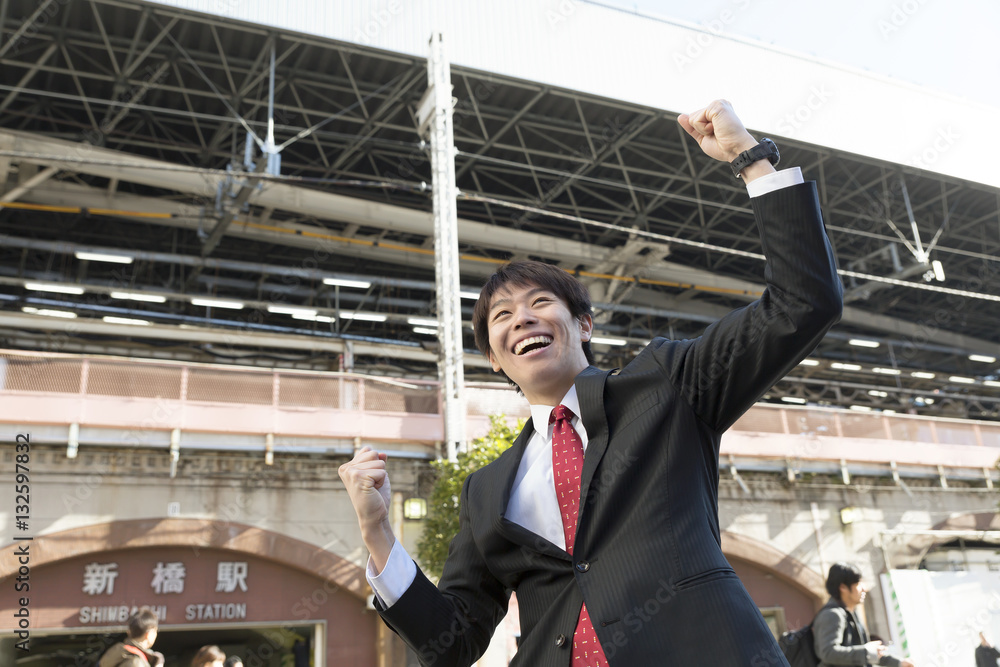 男性　ビジネスマン　ガッツポーズ　新橋駅前　勝利　成功　気合い　笑顔