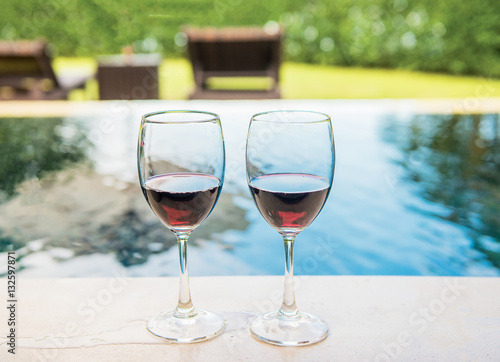 Two glasses of red wine beside the pool,Romantic
