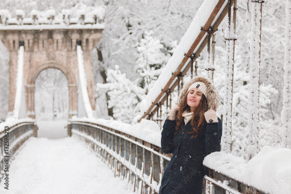 Winter portrait of a beautiful woman in the snowfall
