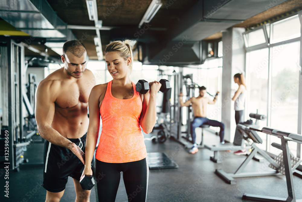 Personal trainer giving instructions in gym Personal trainer giving instructions in gym