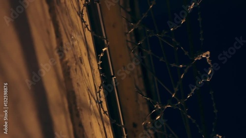 Large fence with barbed wire in the night.