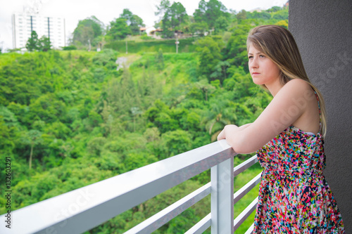 serious girl looking the nature landscape through her balcony Free Download serious girl looking the nature landscape through her balcony - GFXLoad