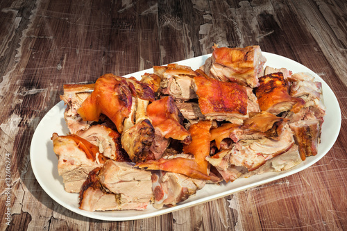 Plateful of Spit Roasted Pork Shoulder Slices Set on Old Cracked Flaky Wooden Garden Table
