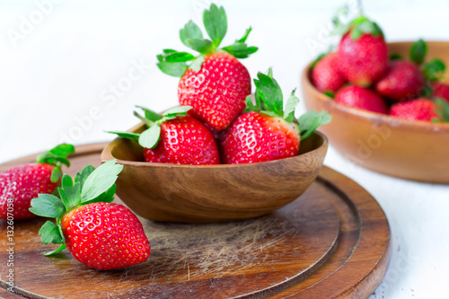 Ripe strawberry in the background bowl of berries  selective foc