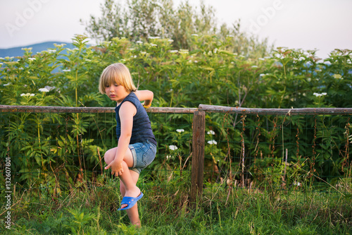 Little boy playing outdoors in countryside on a warm nice day photo