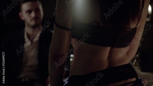 Slim woman dancing for man in lingerie back to camera