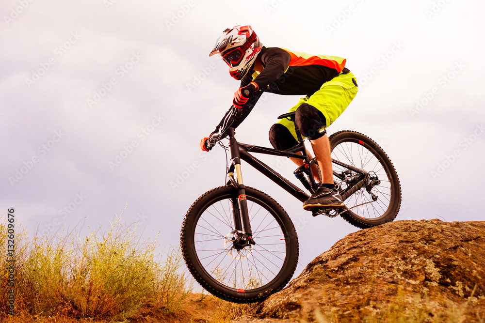Professional Cyclist Riding the Bike Down Rocky Hill. Extreme Sport Concept. Space for Text. Professional Cyclist Riding the Bike Down Rocky Hill. Extreme Sport Concept. Space for Text.