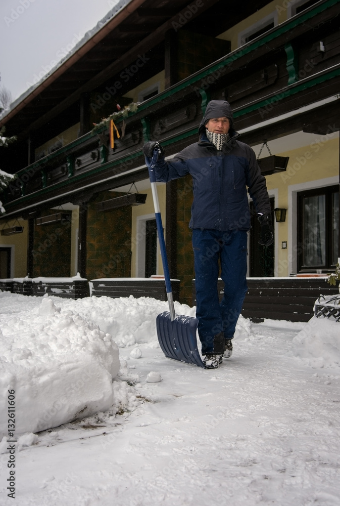 Adult man gather snow with shovel