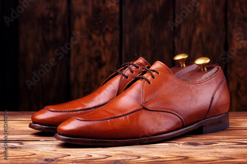 Fashionable leather derby shoes for men on wooden background