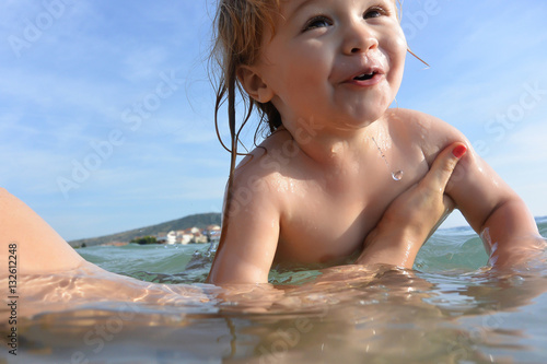 Cute child lerns to swim in water. © Volodymyr
