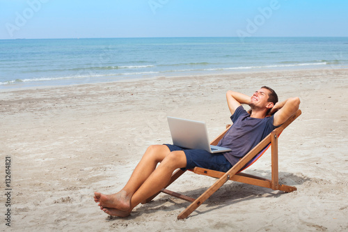 freelancer with laptop on the beach, successful happy business man relaxing, freelance work © Song_about_summer