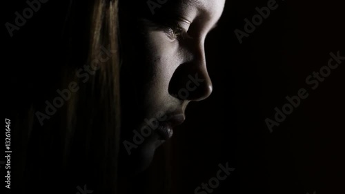 7Closeup portrait of a depressed teen girl in the dark. 4K UHD.
