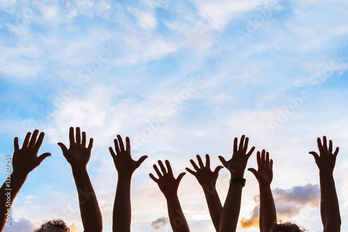 community initiative or volunteering concept, hands of group of people in the sky, silhouette