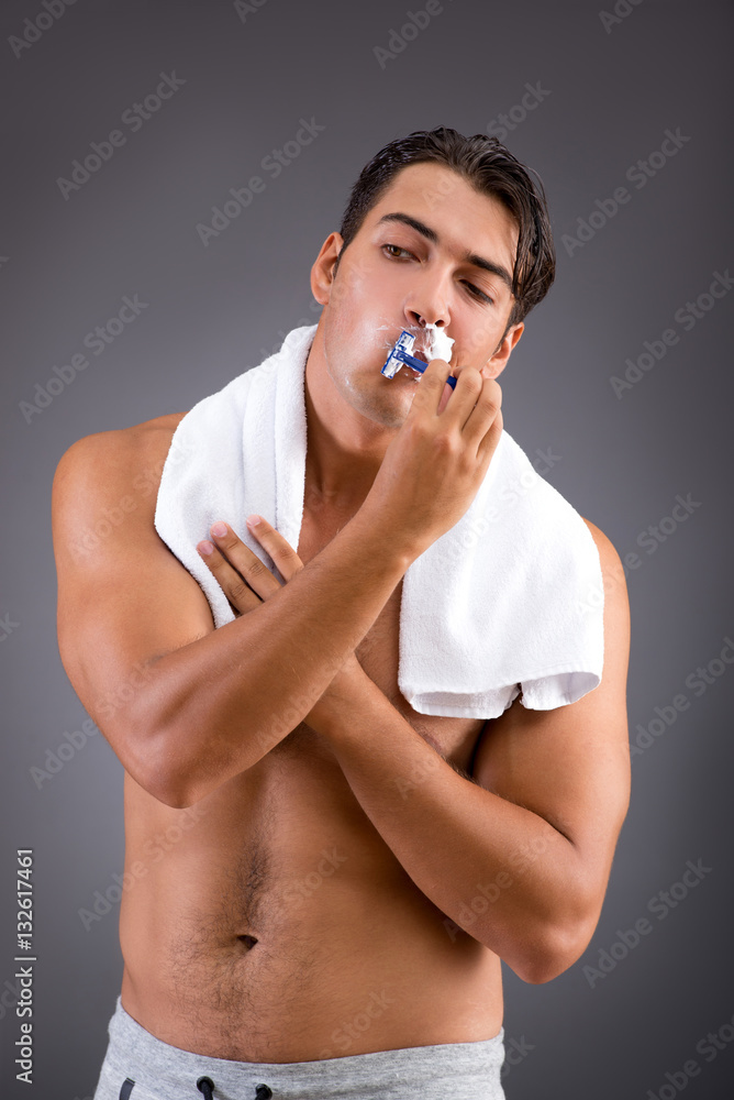 Handsome man shaving against dark background Handsome man shaving against dark background