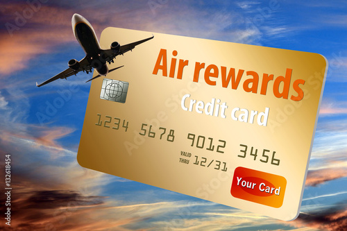 Credit card that offers air mile rewards is seen with a jet plane and dusky sky background photo