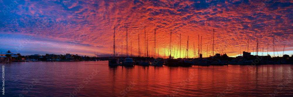Crimson and Blue marina Sunset with water reflections and boats in silhouette.
Photo was taken at Mooloolaba, Queensland, Australia.
