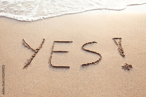 YES concept, positive changes in the life, word written on sand beach.