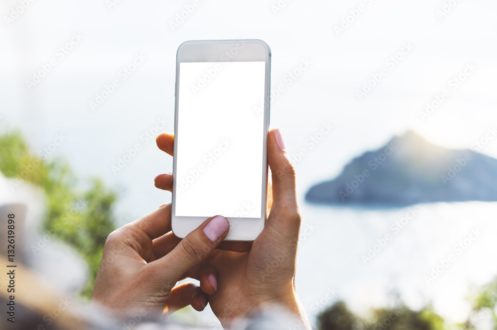 Hipster girl texting message on smartphone mobile closeup, view tourist hands using gadget phone in travel on background mountains and sky landscape; finger touch screen cellphone mockup nature