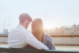 dating or first love, young couple sitting together on the bench, view from the back