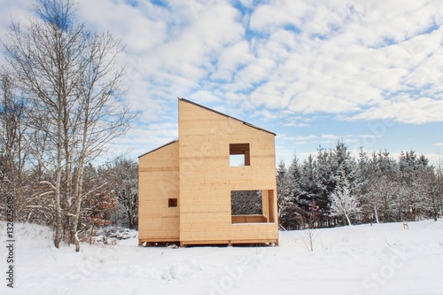 Snowy site ecological house. The wooden house in the woods. 