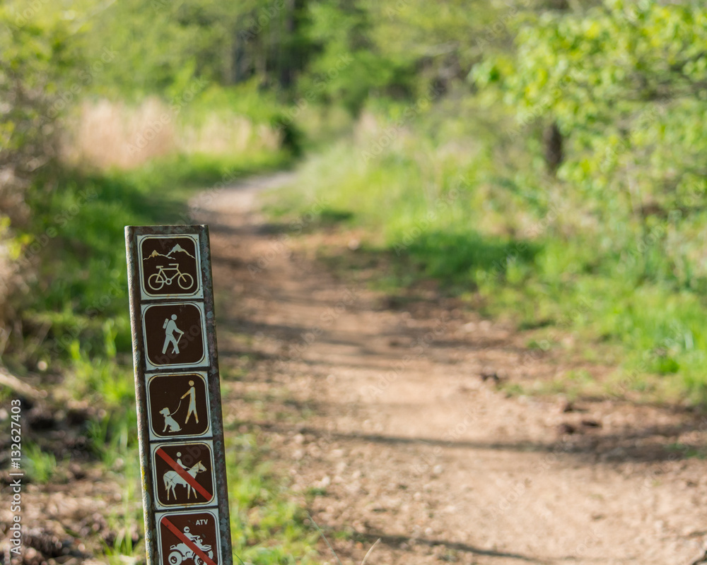Trail marker with trail in background