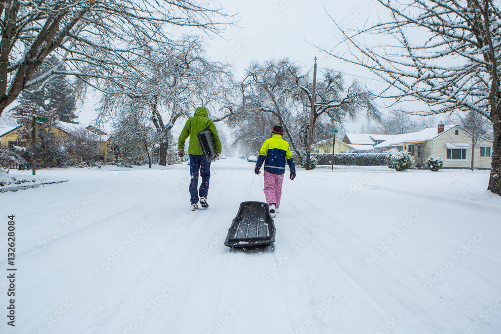 Children walk down the center of an empty street dragging sleds in the  freshly fallen winter snow. Stock Photo | Adobe Stock