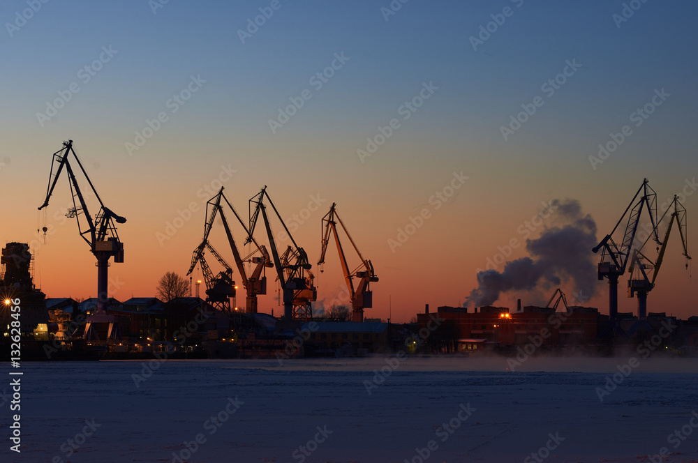 Industrial sea port in winter time. Crane on mornin sky background. Work city landscape. Saint-Petersburg.