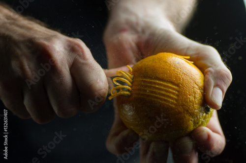 Manos rayando una naranja