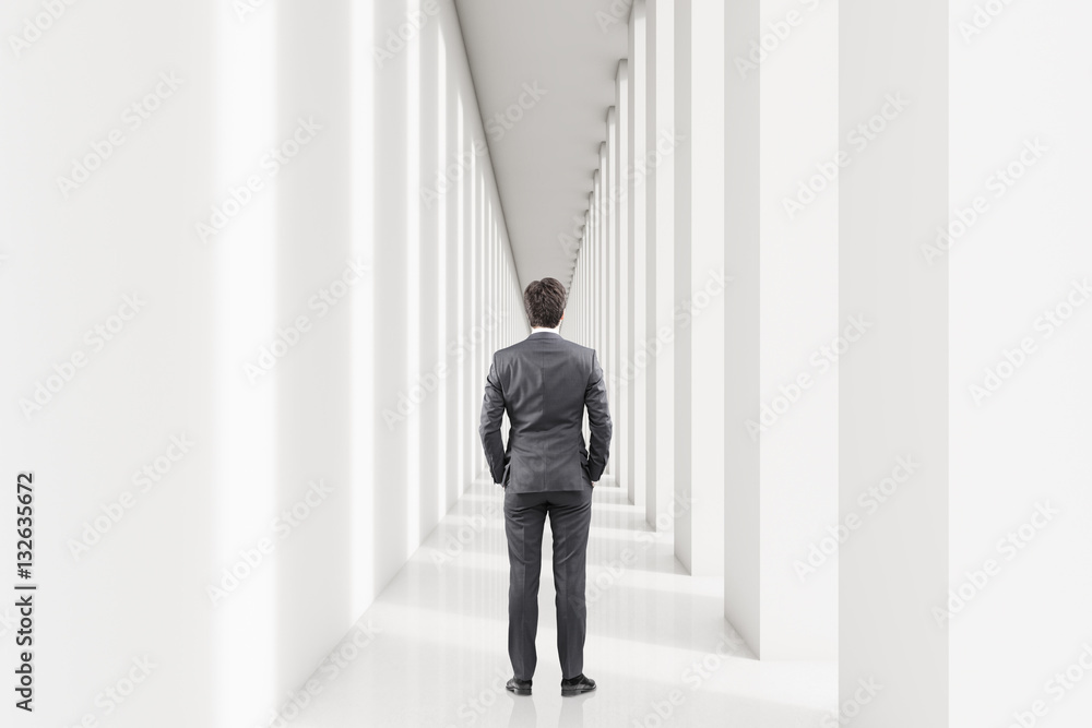 Rear view of a businessman in a white corridor Rear view of a businessman in a white corridor