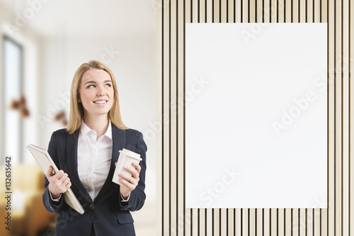 Smiling bond girl near poster in restaurant photo