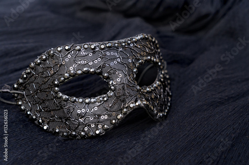 One festive mask on black silk background