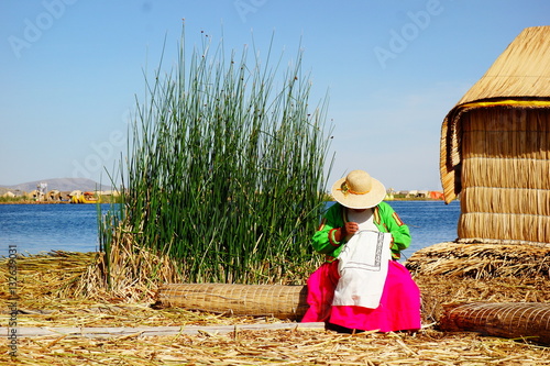 фотографія embroidering woman at floating island in peru, titikaka lake
