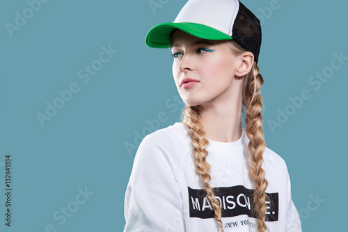 Photography Woman in a baseball cap and a white sweatshirt is on a blue background