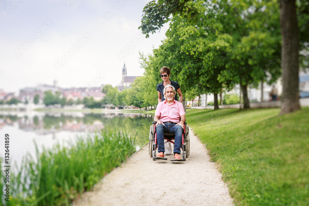 Senior Couple In Wheelchair, Enjoying A Day In The Park Senior Couple In Wheelchair, Enjoying A Day In The Park