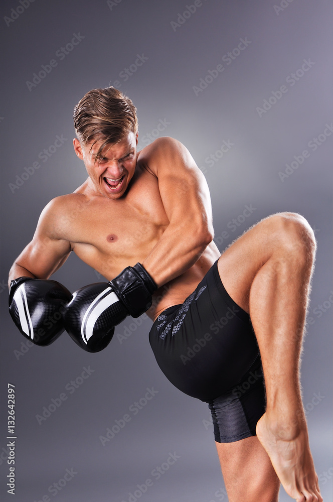 Handsome Muscular Fighter Practicing Knee Kick. Concept of Healthy Lifestyle.