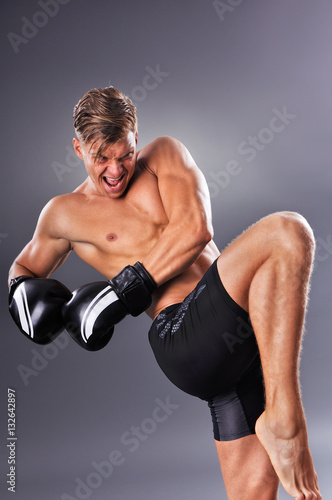 Handsome Muscular Fighter Practicing Knee Kick. Concept of Healthy Lifestyle. © cirkoglu