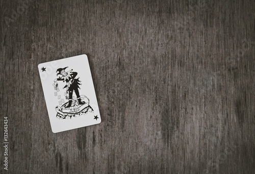 playing cards black joker on a wooden table background, space for you text, game risk abstract.
