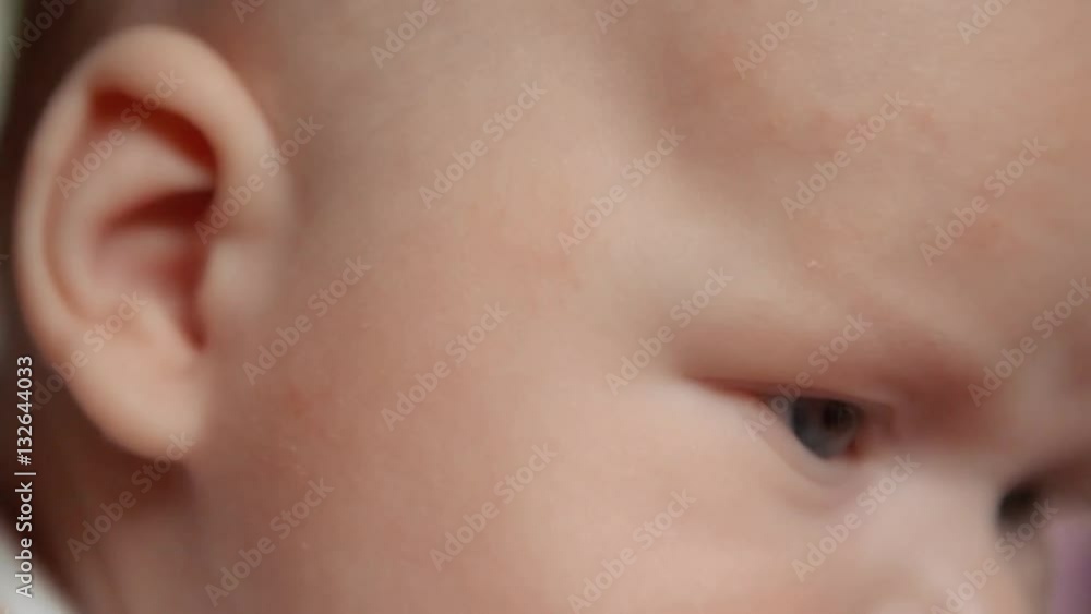 Baby looks away in embarrassment. Close up of baby's face. Notice the reflections in the eyes. Baby looks away in embarrassment. Close up of baby's face. Notice the reflections in the eyes.