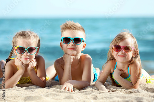 Cute kids lying on beach sand