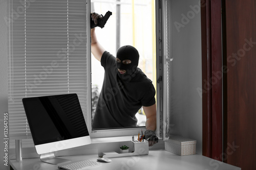 Thief with gun entering office through window