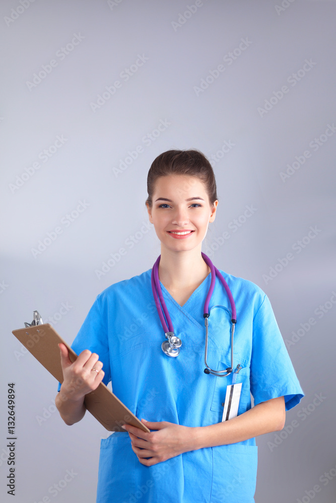 Smiling female doctor with a folder in uniform standing at hospital Smiling female doctor with a folder in uniform standing at hospital