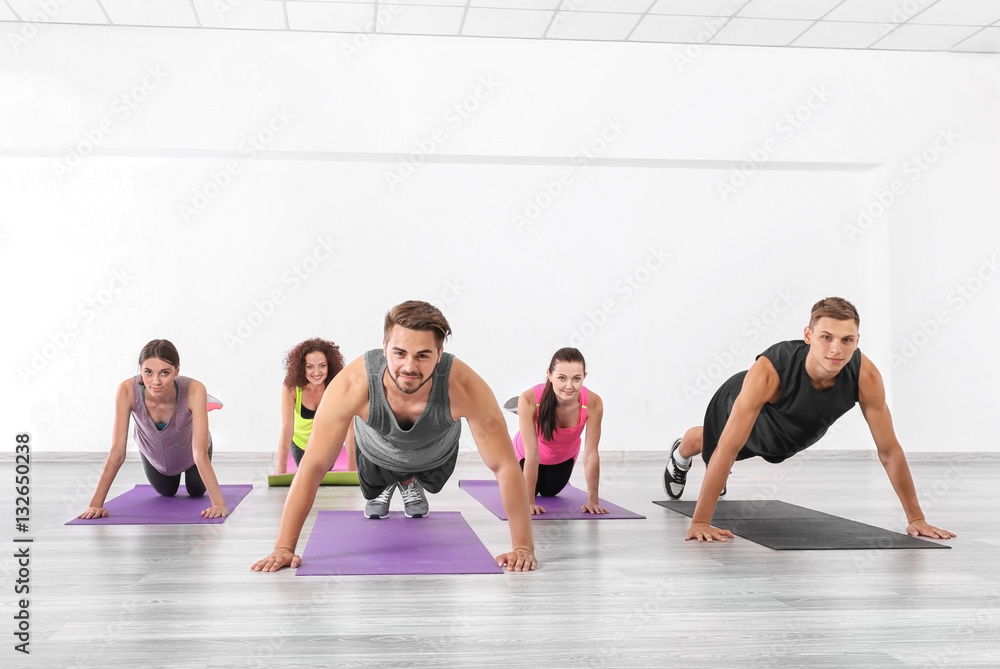 Group of people doing push-ups in yoga class Group of people doing push-ups in yoga class