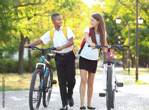 Teenagers with bicycles wal...