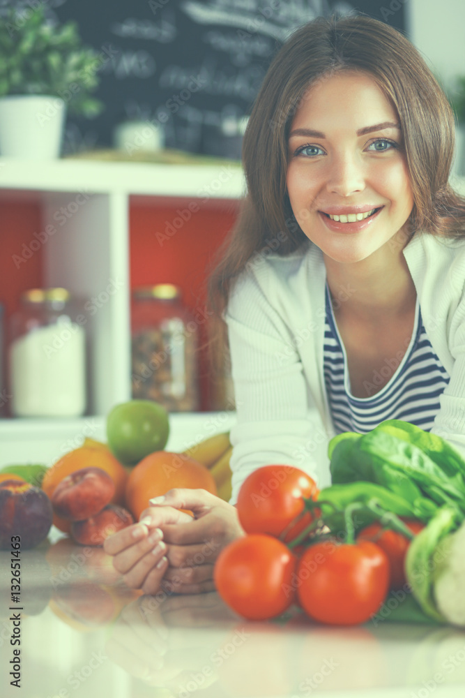 Young woman standing near desk in the kitchen Young woman standing near desk in the kitchen